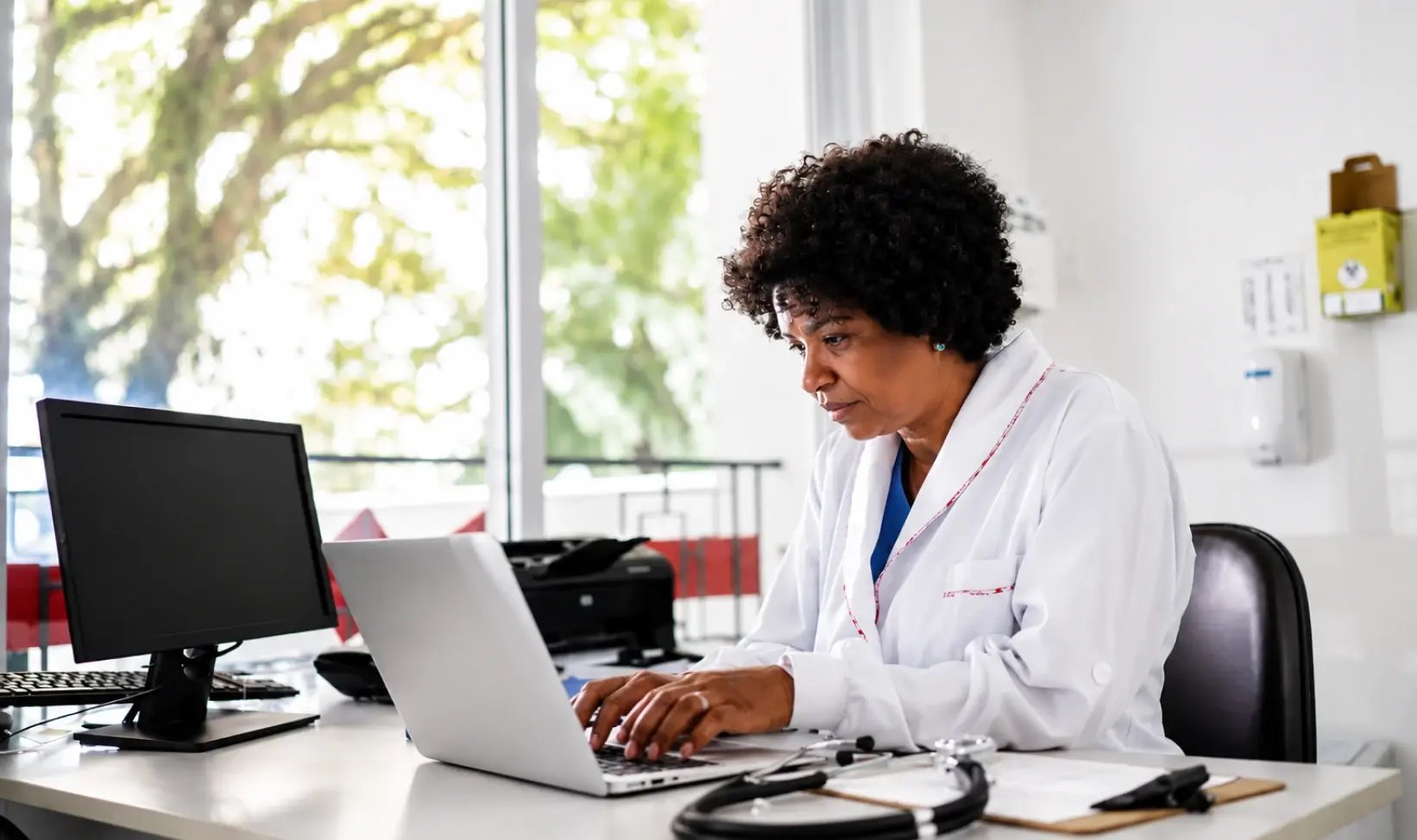 Healthcare professional working on a laptop in a medical office